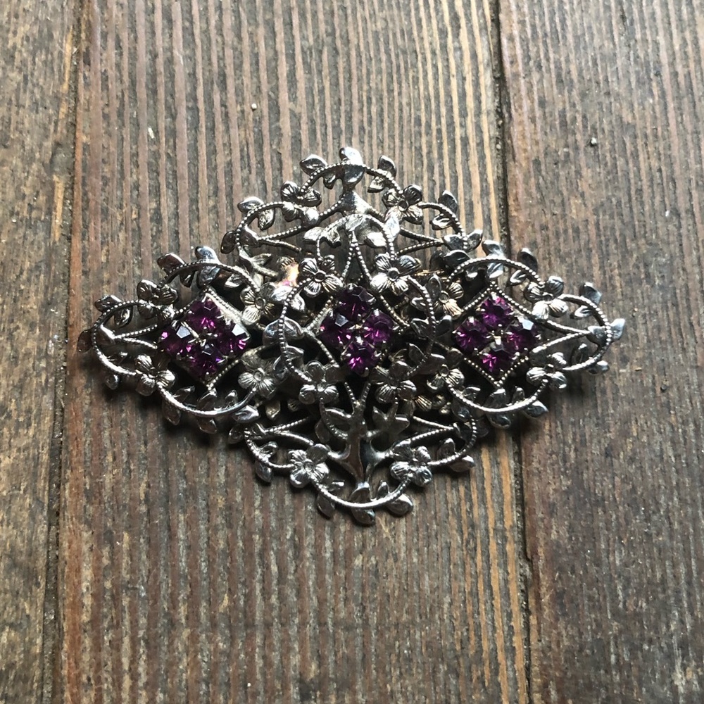 Ornate silver tone brooch with amethyst
